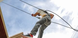 man wearing harness going down building