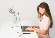 woman in pink dress using laptop computer