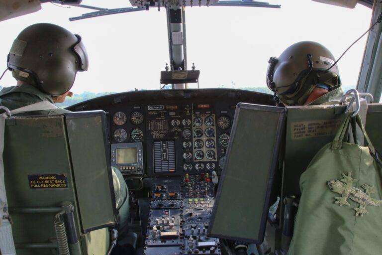 unrecognizable combat pilots in helicopter cockpit