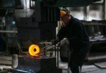 man lifting hot metal