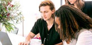 man working on laptop while woman takes notes