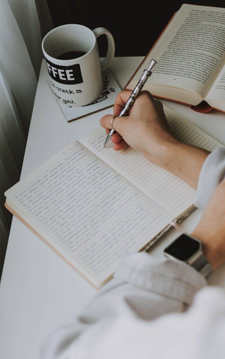 person writing on notebook