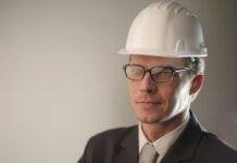 man in black suit jacket wearing hard hat