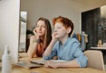 photo of woman and boy leaning on wooden table