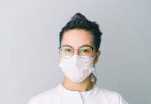photo of person wearing protective wear while holding globe