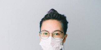 photo of person wearing protective wear while holding globe