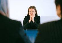 woman in black blazer sitting being interview