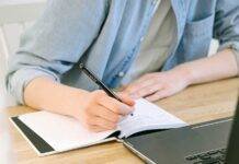 person writing on a notebook