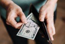 unrecognizable man holding wallet with money