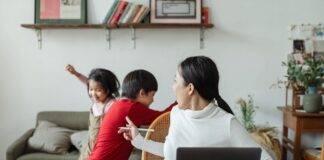 young ethnic woman trying to work at home with active children