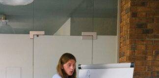 employee drawing graph on flipchart during meeting in workspace