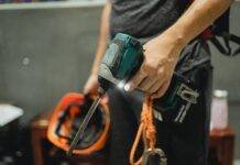 crop repairman standing with working screwdriver and orange helmet