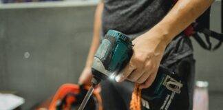 crop repairman standing with working screwdriver and orange helmet