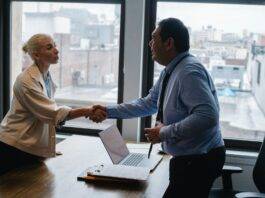 young woman shaking hands with boss after business presentation