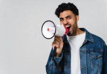 man in blue denim jacket holding a megaphone