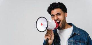 man in blue denim jacket holding a megaphone