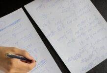 student writing in papers with homework task