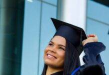 cheerful latin american woman in graduation outfit