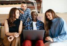 multiethnic coworkers watching plan on laptop
