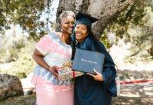 gray haired woman smiling beside the newly graduate student