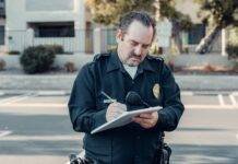 a bearded police man writing on paper