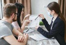 a woman explaining a document to a couple