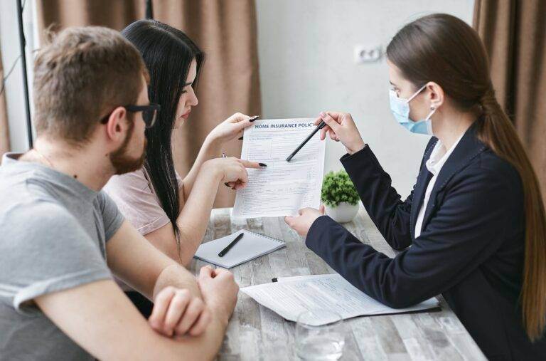 a woman explaining a document to a couple