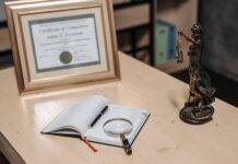 an open book on the table with magnifying glass and a pen