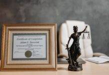 a certificate and lady justice figurine on table