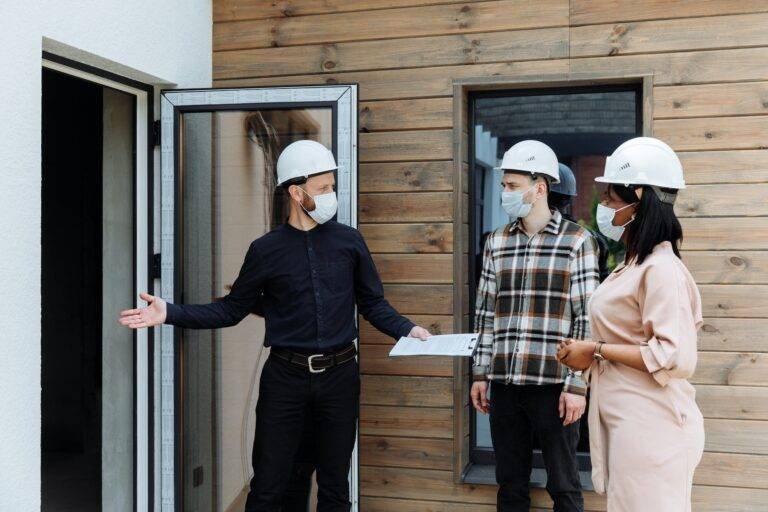 a man in black long sleeves talking to the couple while showing the house