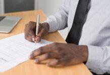 person wearing white dress shirt signing contract