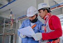 two man holding white paper