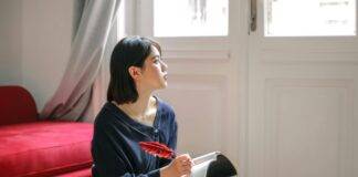 thoughtful woman writing in notebook at home
