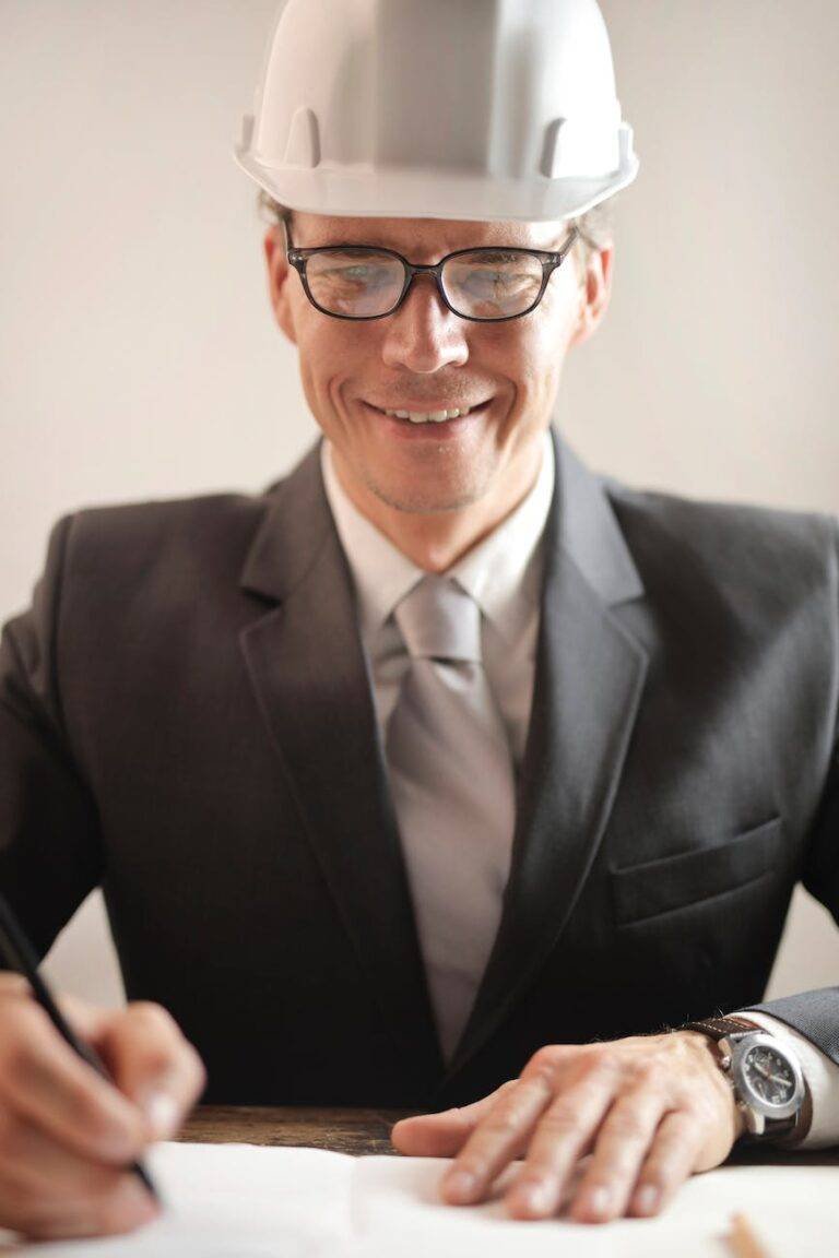 man in black suit signing a paper works