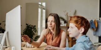 photo of woman tutoring young boy