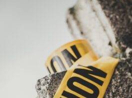inscription caution on yellow tape on stone