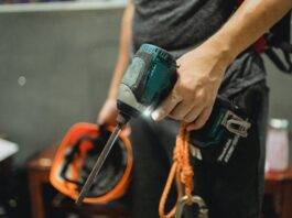 crop repairman standing with working screwdriver and orange helmet