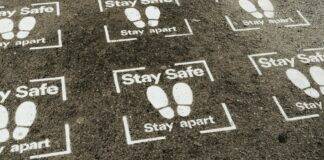 asphalt road with inscription stay safe stay apart
