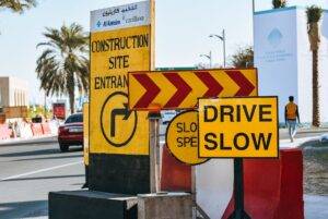 road in modern city with yellow warning traffic signs