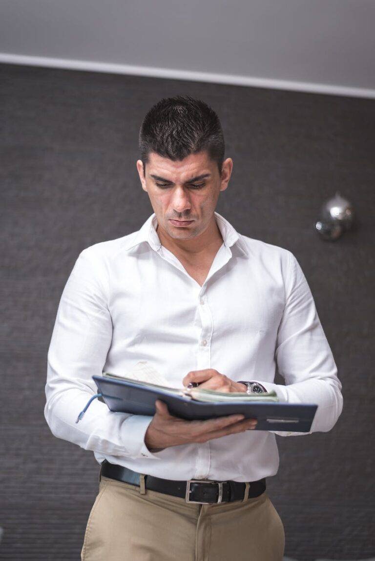 man in white dress shirt holding a planner