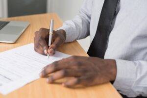 person wearing white dress shirt signing contract