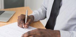 person wearing white dress shirt signing contract