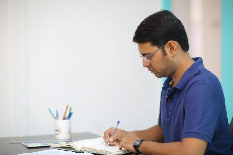 man in blue polo shirt writing