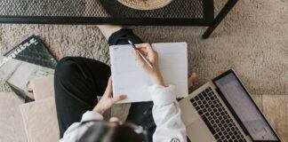 faceless lady with notebook and laptop on floor at home