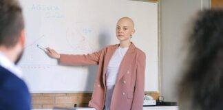 bald woman near whiteboard with charts