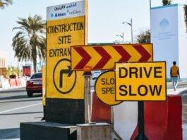 road in modern city with yellow warning traffic signs