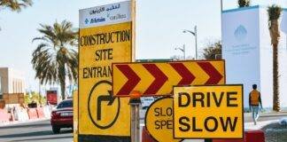 road in modern city with yellow warning traffic signs