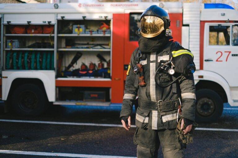 a firefighter in uniform standing near a fire truck