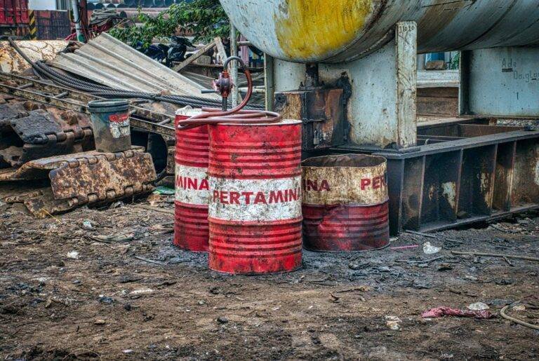 aged metal barrels placed on a landfill