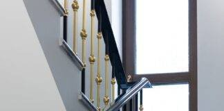 staircase with marble steps and metal banister in house